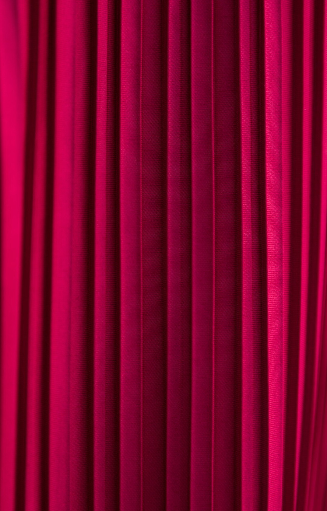 Red theater stage curtains lit by a single spotlight